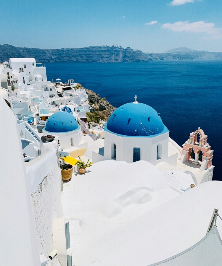 Santorini Greece white buildings blue domes caldera sunset