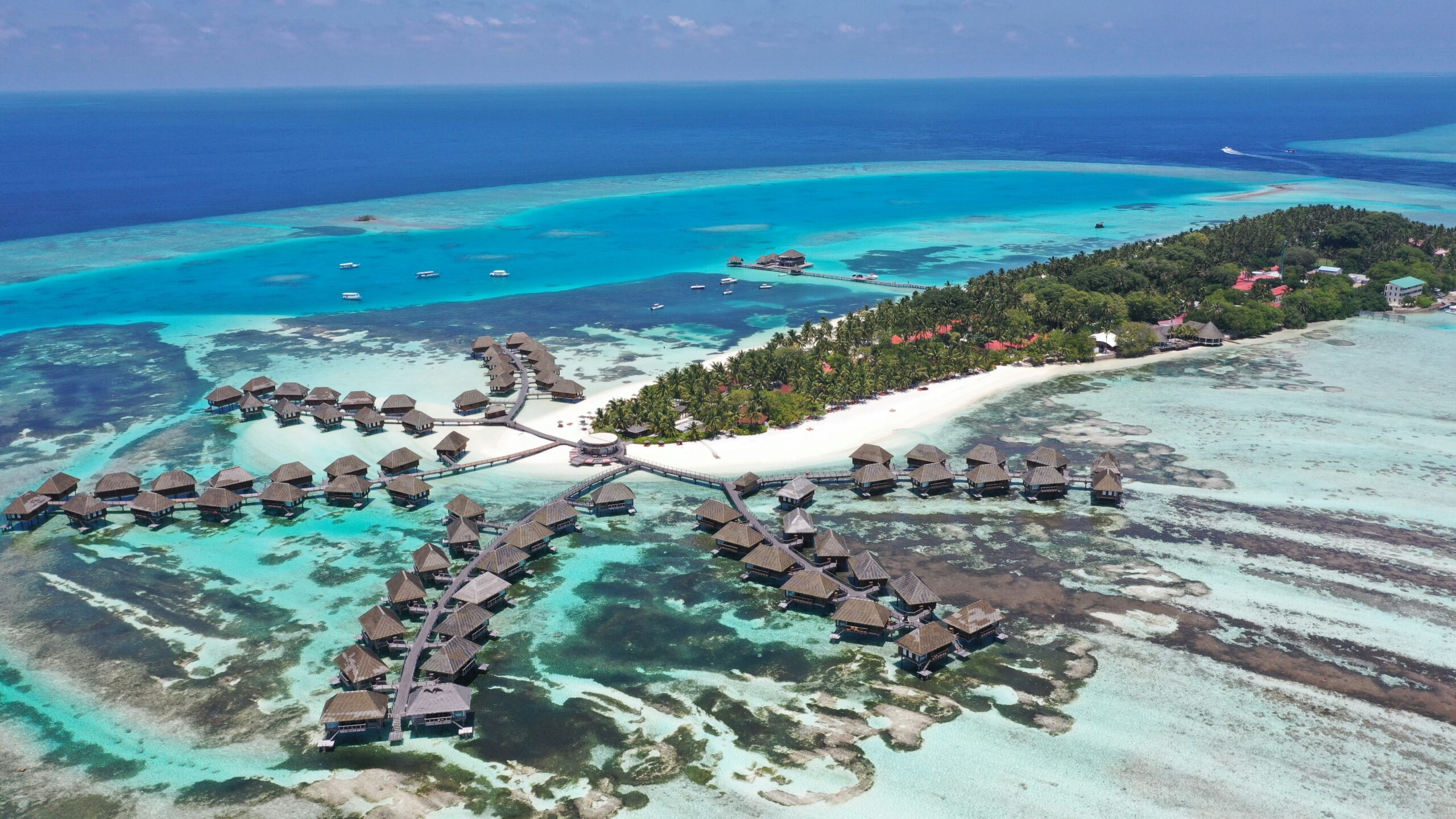 Maldives overwater bungalows crystal lagoon coral reef Indian Ocean